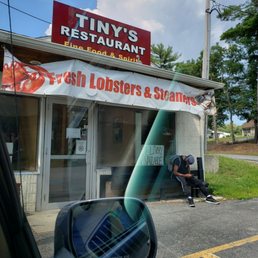 a man sitting on a bench in front of a restaurant
