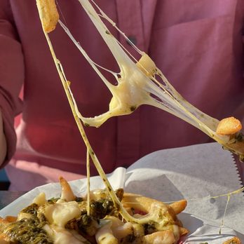 ArtsRiot - a plate of french fries with cheese and pesto - Bars Near Me - Burlington, Vermont ArtsRiot - a plate of french fries with cheese and pesto - Bars Near Me - Burlington, Vermont