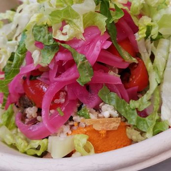 CAVA - Braises pork, lettuce, purple onions, baby tomatoes, quinoa, topped with feta and red pepper dip all over rice. - Mediterranean Near Me - Bethesda, Maryland