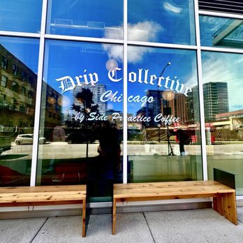 Drip Collective - The image shows a large glass window with the business name 'Drip Collective Chicago' and additional text, reflecting the street scene outside, including buildings and cars. - Coffee & Tea Near Me - Chicago, Illinois