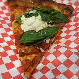 a slice of pizza on a red and white checkered paper plate
