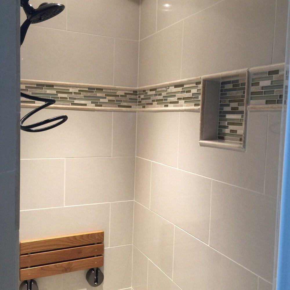 Cultured Creations - Porcelain tile shower with niche and glass mosaic deco band. - General Contractors Near Me - Columbia, South Carolina