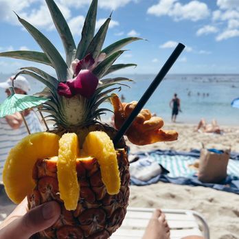 Waikiki Beachside Bistro - a person holding a pineapple drink - Asian Fusion Near Me - Honolulu, Hawaii Waikiki Beachside Bistro - a person holding a pineapple drink - Asian Fusion Near Me - Honolulu, Hawaii