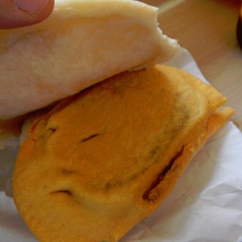 Concourse Jamaica Bakery - Placing the beef patty into the coco bread.  These critters are amazing! - Bakeries Near Me - Bronx, New York