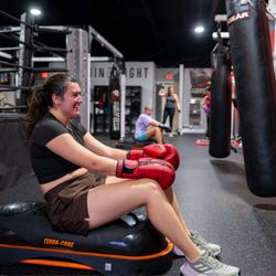 Omni Fight Club Roswell member taking a recovery break during a boxing fitness class, highlighting the supportive, real-world...