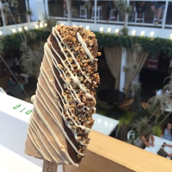 Popbar - Hazelnut gelato half dipped in milk chocolate, drizzled with white chocolate with hazelnut, almonds and waffle cones! - Desserts Near Me - Anaheim, California Popbar - Hazelnut gelato half dipped in milk chocolate, drizzled with white chocolate with hazelnut, almonds and waffle cones! - Desserts Near Me - Anaheim, California
