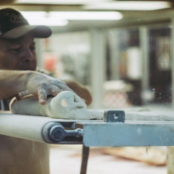 Shipley Do-Nuts - a man sanding a piece of wood - Donuts Near Me - McAllen, Texas