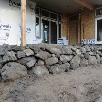 Moore's Works - a large pile of rocks in front of a house - Landscaping Near Me - Indianola, Washington Moore's Works - a large pile of rocks in front of a house - Landscaping Near Me - Indianola, Washington