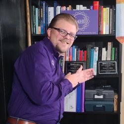 Michigan Hypnosis Institute - Michael D. Milson, CC.Ht, CAHA, MPNLP pointing at his Directors Award, Academic Achievement Award & Clinical Achievement Award.