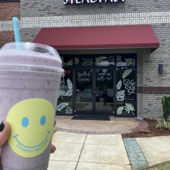 Steadfast Nutrition - a purple smoothie with a smiley face drawn on it - Juice Bars & Smoothies Near Me - Hampstead, North Carolina Steadfast Nutrition - a purple smoothie with a smiley face drawn on it - Juice Bars & Smoothies Near Me - Hampstead, North Carolina