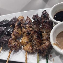 Mushroom skewers, spicy chicken and beef. Teriyaki sauce I think and peanut sauce