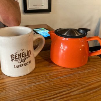 Benelux Café - a coffee pot and a mug on a table - Coffee & Tea Near Me - Raleigh, North Carolina