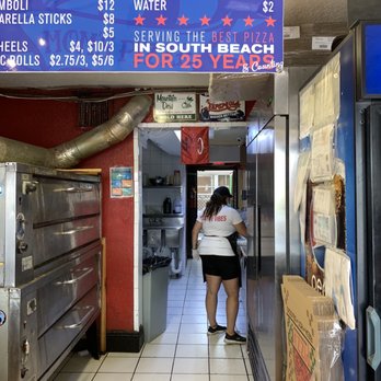 Mom's New York Pizza - a woman walking through a restaurant - Pizza Near Me - Miami Beach, Florida Mom's New York Pizza - a woman walking through a restaurant - Pizza Near Me - Miami Beach, Florida