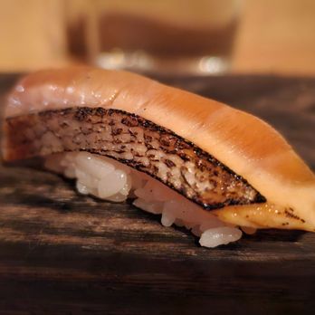 Nimblefish - a piece of sushi on a cutting board - Sushi Bars Near Me - Portland, Oregon