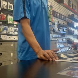 Gamestop - A gentlemen smiling in a condescending manner as he thinks he can treat customers however he wants.