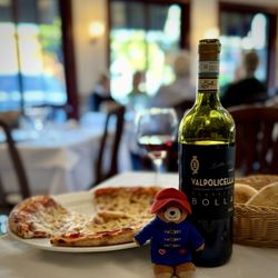 Piazza Romana - Pepperoni and cheese pizza with a red bottle of wine