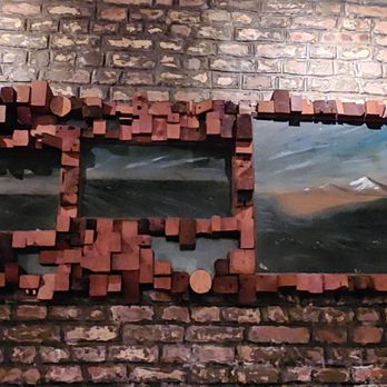 Palo Santo - a view of a mountain through a broken brick wall - Latin American Near Me - Brooklyn, New York