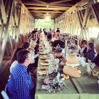 Made From Scratch - Guests sitting down to a Tuscan-style dinner on a covered bridge. - Caterers Near Me - Plain City, Ohio
