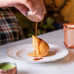 Lotus Cuisine of India - A golden samosa finished with sweet tamarind chutney. Mint chutney on the side for the extra kick.
#veganfood #seedoilfree #glutenfree