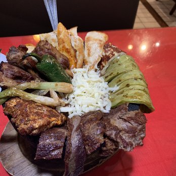 Bonito Sinaloa - Molcajete Azteca con chorizo, carne, pollo, costillas, queso, nopales, cebollita, and not pictured the side of rice and beans. - Mexican Near Me - Anaheim, California
