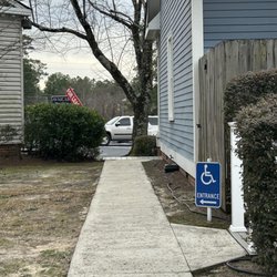 The sidewalk leads to a ramp at the front.