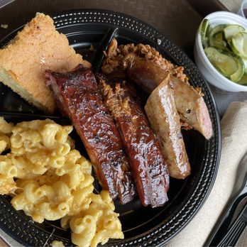 Tennessee's Real BBQ Real Fast - Piggy Party Special - a mound of pulled pork is hiding under those ribs and sausage. - Barbeque Near Me - Framingham, Massachusetts