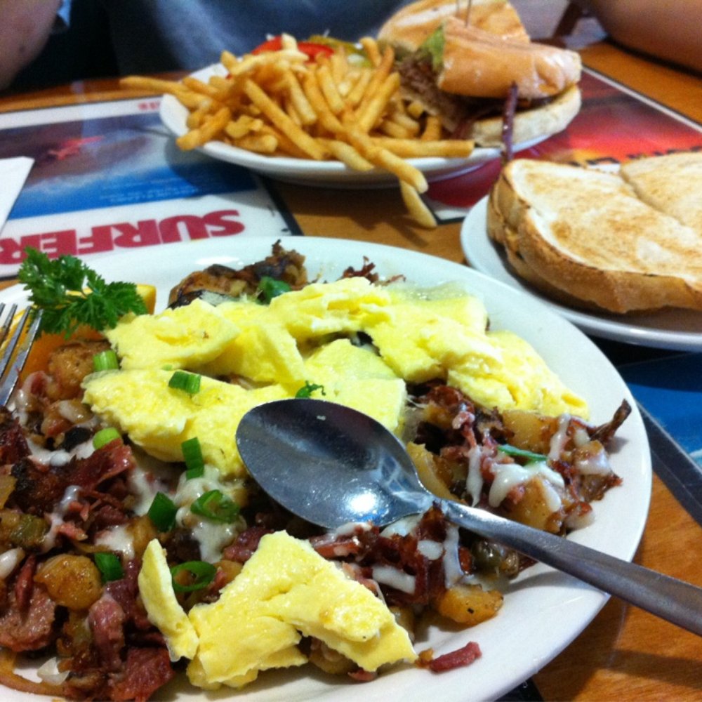 Beach Break Cafe - Foreground: corned beef hash with scrambled eggs and sourdough bread. Background: danger burger with fries - Breakfast & Brunch Near Me - Oceanside, California