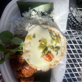 Gobble This - Diablo shrimp bowl - A tray holds white rice, a cheesy dish topped with peppers, and glazed chicken pieces, with a small plant garnish. - Salvadoran Near Me - Albuquerque, New Mexico