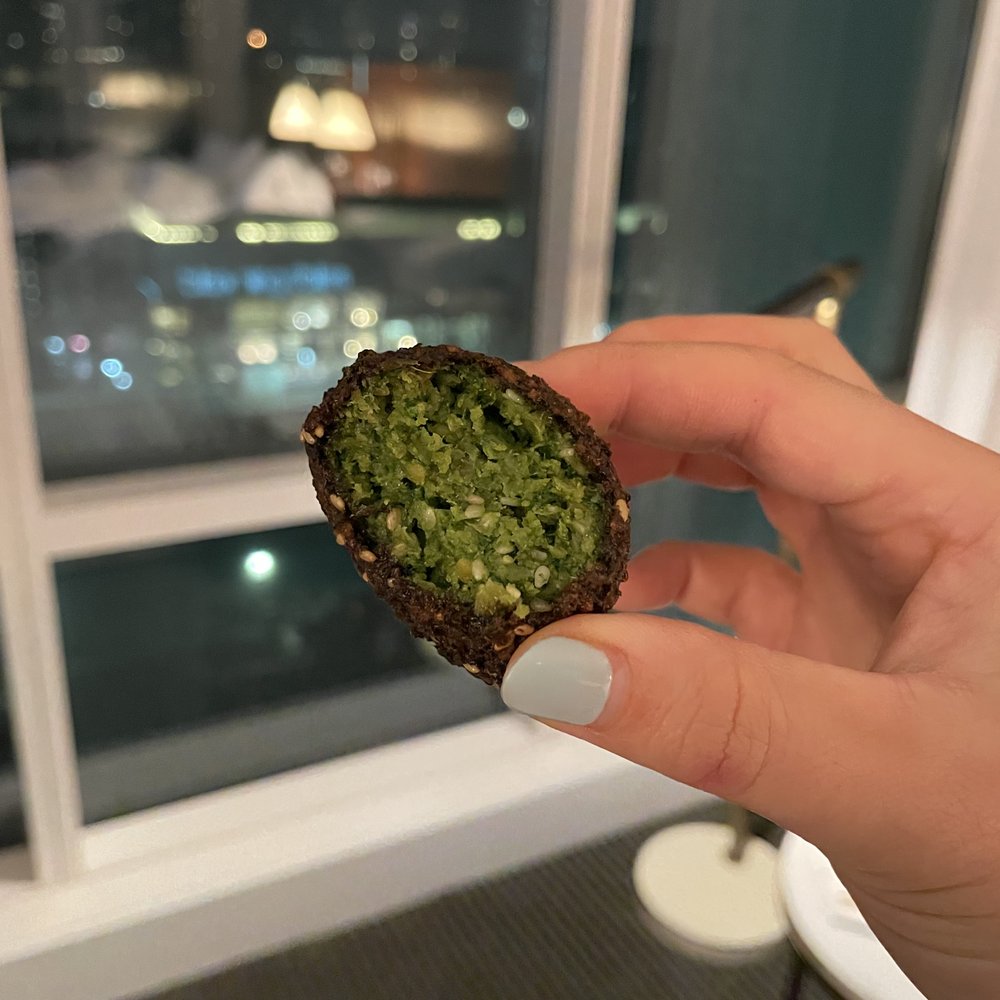 Truly Mediterranean - a hand holding a piece of food - Mediterranean Near Me - San Francisco, California Truly Mediterranean - a hand holding a piece of food - Mediterranean Near Me - San Francisco, California