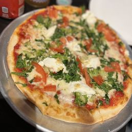 a pizza with tomatoes and spinach