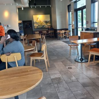 Starbucks - two people sitting at tables in a coffee shop - Coffee & Tea Near Me - Buffalo, New York Starbucks - two people sitting at tables in a coffee shop - Coffee & Tea Near Me - Buffalo, New York