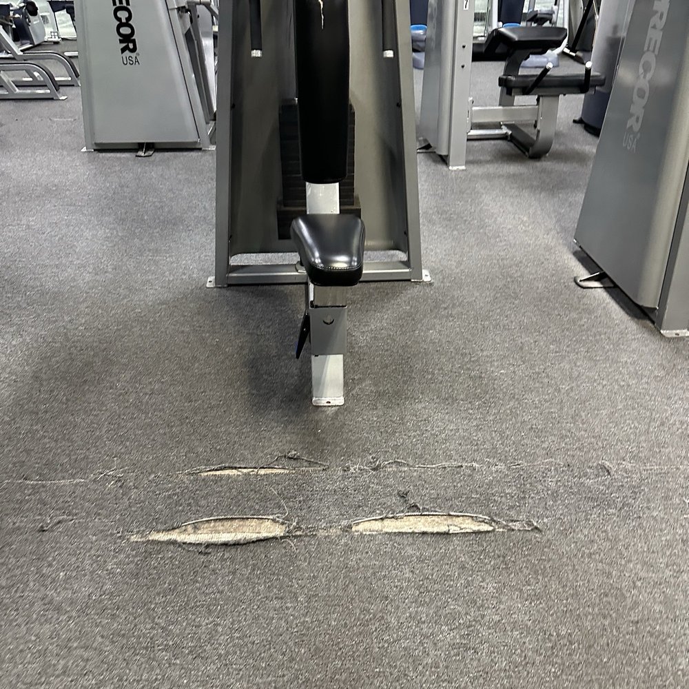 EnerGYM NorthJAX - Chest press machine with a visibly torn and worn-out carpet area in front of it. - Gyms Near Me - Jacksonville, Florida EnerGYM NorthJAX - Chest press machine with a visibly torn and worn-out carpet area in front of it. - Gyms Near Me - Jacksonville, Florida