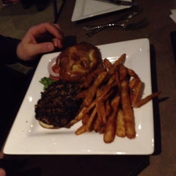 River Rock Grille - Burger on a pretzel bun with burnt fries - American Near Me - Holly, Michigan