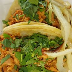 Two chicken tacos with cilantro and onions on the side. $2 each
