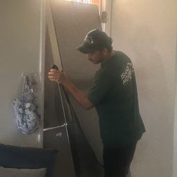 Island Movers - Carefully moving out the old fridge through a narrow doorway.
