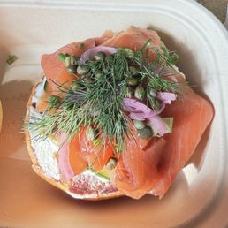 Salmon brioche open sandwich with just bottom piece of bread.