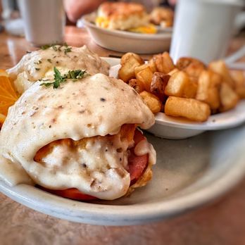 Skillets Cafe & Grill - This is the Southern Benedict that comes with ham and gravy, and a side of country potatoes. - Breakfast & Brunch Near Me - Hilton Head Island, South Carolina Skillets Cafe & Grill - This is the Southern Benedict that comes with ham and gravy, and a side of country potatoes. - Breakfast & Brunch Near Me - Hilton Head Island, South Carolina