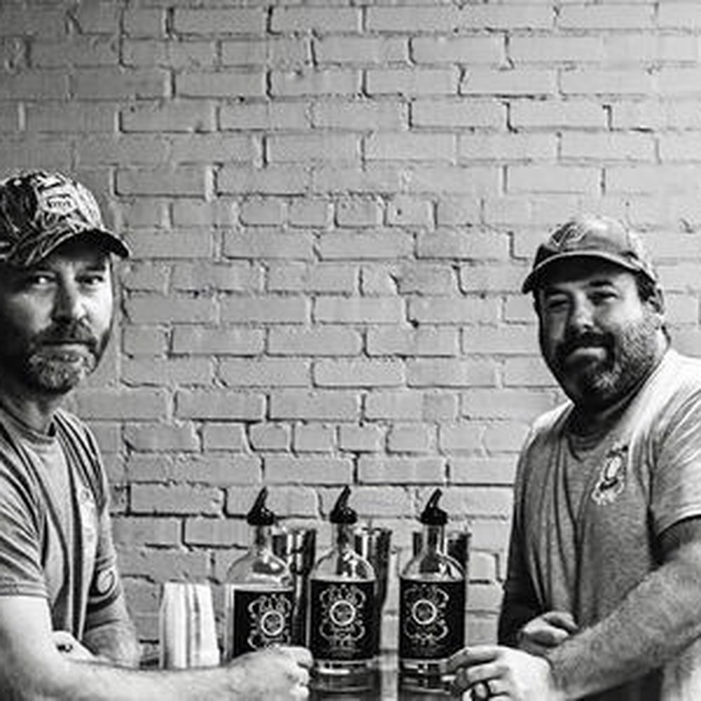 Lick Life Spirits - two men shaking hands with bottles - Distilleries Near Me - Zebulon, North Carolina Lick Life Spirits - two men shaking hands with bottles - Distilleries Near Me - Zebulon, North Carolina