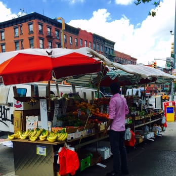 fruit stand - a man standing in front of a fruit stand - Fruits & Veggies Near Me - New York, New York