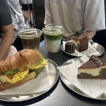 The Cakery Cafe - Golden Croissant sandwich, hojicha basque cheesecake, vanilla canele, hojicha latte, and matcha latte - Sandwiches Near Me - San Diego, California The Cakery Cafe - Golden Croissant sandwich, hojicha basque cheesecake, vanilla canele, hojicha latte, and matcha latte - Sandwiches Near Me - San Diego, California