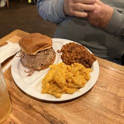 Pulled pork sandwich with Mac and cheese and baked beans.