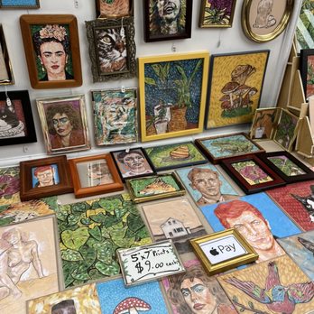 Eugene Saturday Market - a table covered with paintings - Arts & Crafts Near Me - Eugene, Oregon