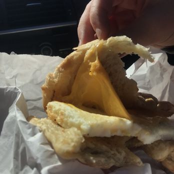 Dunkin' -  a person grabbing a piece of food from a wrapper - Coffee & Tea Near Me - Clemson, South Carolina