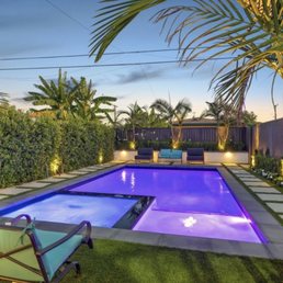 Pool/spa with synthetic grass/pavers and palm trees, roses and ficus trees.