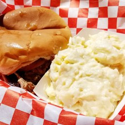 Pulled pork sandwich and side of potato salad. Pulled pork sandwich and side of potato salad.