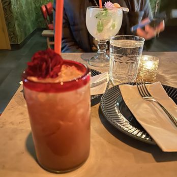 Holic Thai Bistro - a woman sitting at a table with a drink - Thai Near Me - Brooklyn, New York Holic Thai Bistro - a woman sitting at a table with a drink - Thai Near Me - Brooklyn, New York