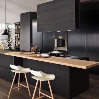 Levi & Sons Construction - a modern kitchen with black cabinets and white stools - General Contractors Near Me - Houston, Texas