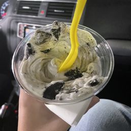 a person holding a cup of ice cream