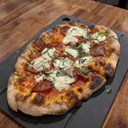 classic cheese pizza with tomato sauce and provolone, topped with Coro pepperoni