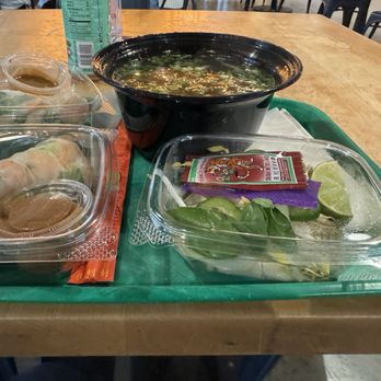Lan Viet - A food tray with Vietnamese dishes such as spring rolls, pho, and fresh herbs with lime wedges, served in a casual dining setting. - Vietnamese Near Me - Dublin, Ohio